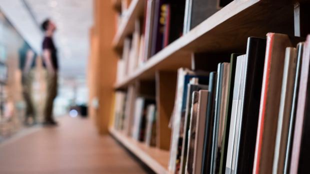 Blurred man looking at library shelves