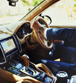 A man in a suit drives a nice car