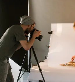 A person taking a photo of a woman in a studio