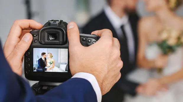 Wedding photographer clicking photo of a married couple
