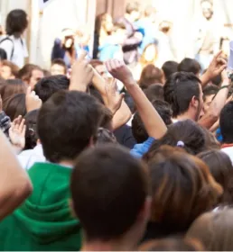 Image of a very crowded place and people having their hands raised