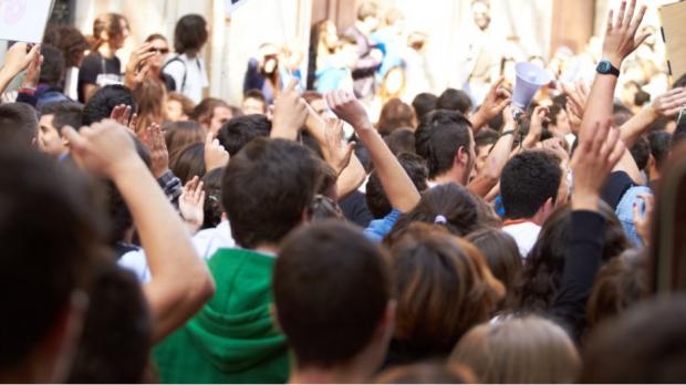 Image of a very crowded place and people having their hands raised