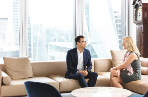 Howden Broking Employees sitting on an office sofa and talking business