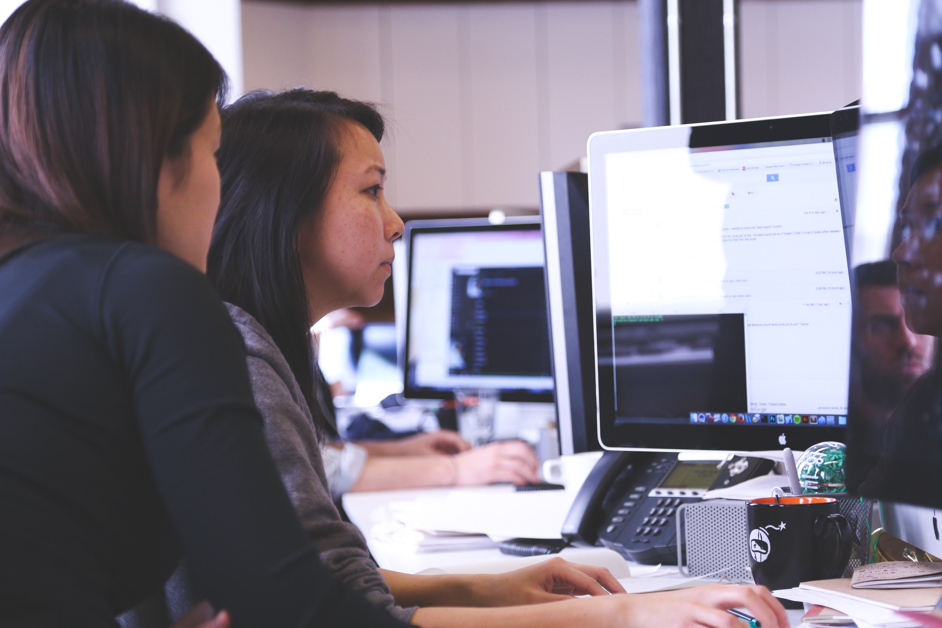 Two actuaries looking at a computer