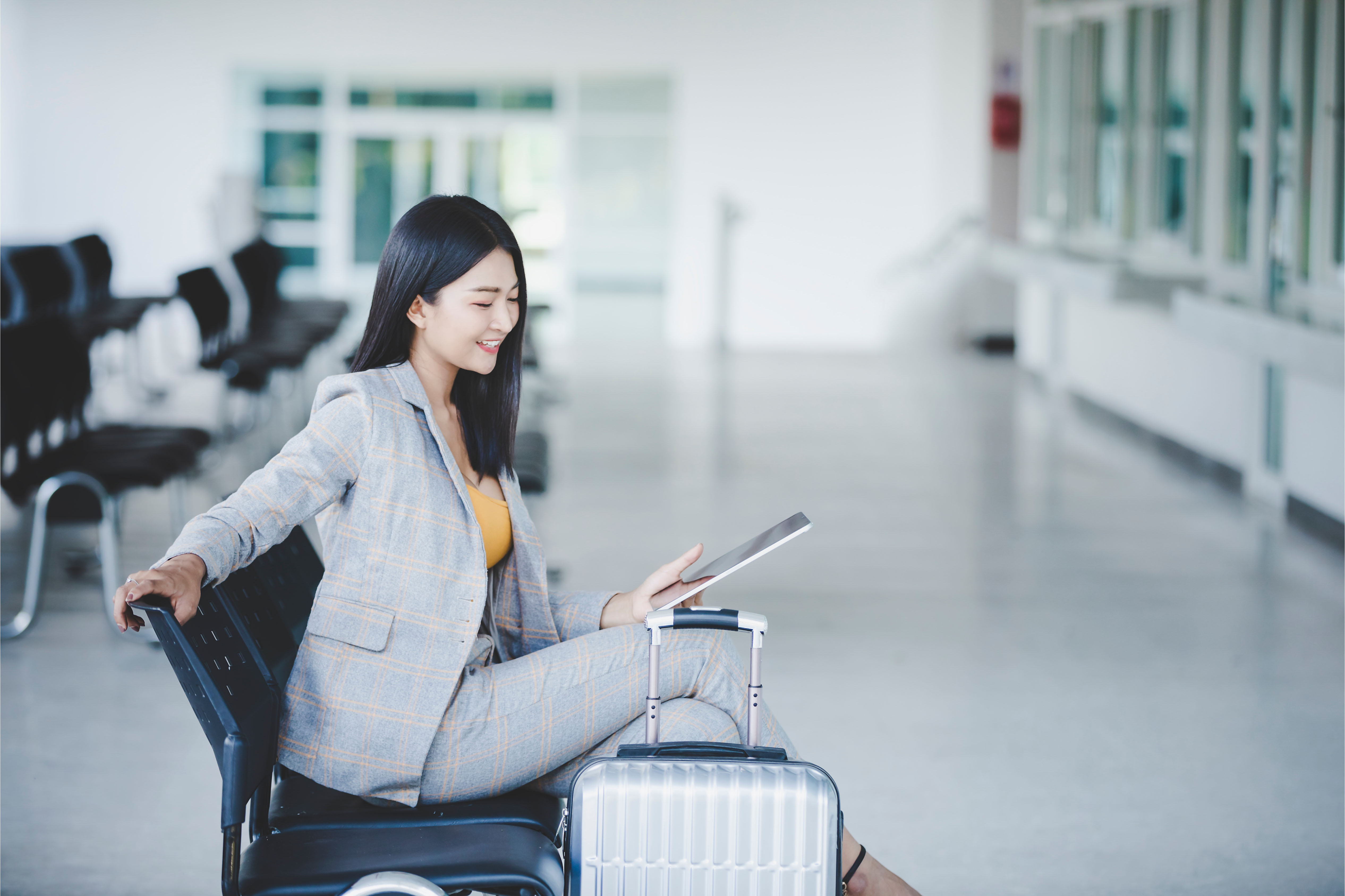 Businesswoman with Tablet and Suitcase at the Airport