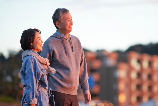 Smiling senior couple enjoying a serene sunset, reflecting emotional wellness and contentment during retirement.