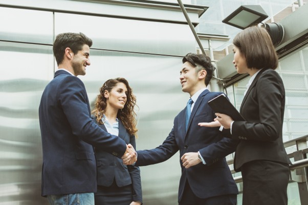 Professionals from different backgrounds greeting each other with a handshake in an urban business