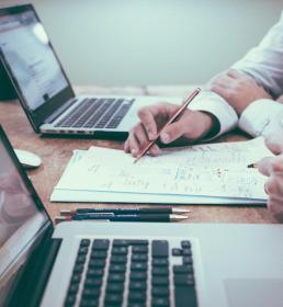 Doing paperwork next to a laptop