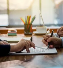 Two people sat at a desk reviewing a document