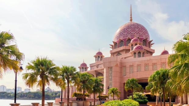 A beautiful mosque with palm trees leading up