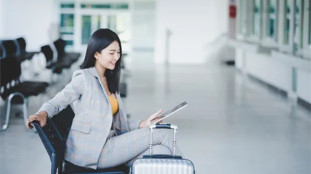 Businesswoman with Tablet and Suitcase at the Airport