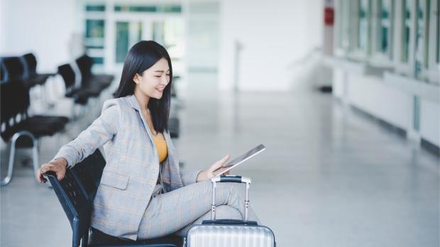 Businesswoman with Tablet and Suitcase at the Airport