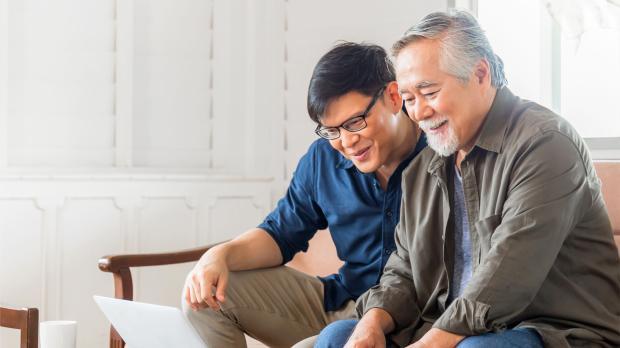 Happiness Senior Asian Father and Adult Son Using Laptop Talking