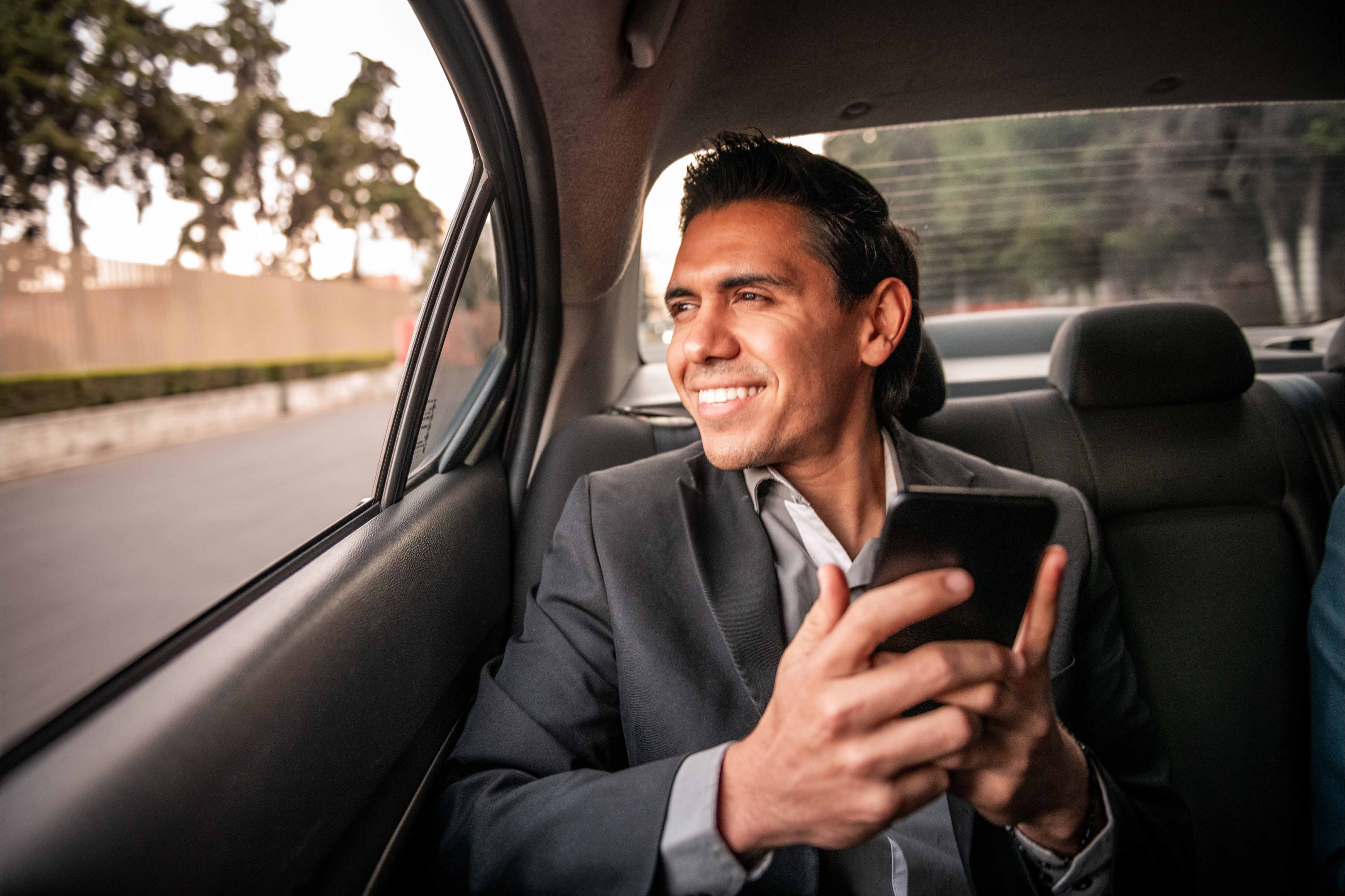 businessman in the back of a car commuting
