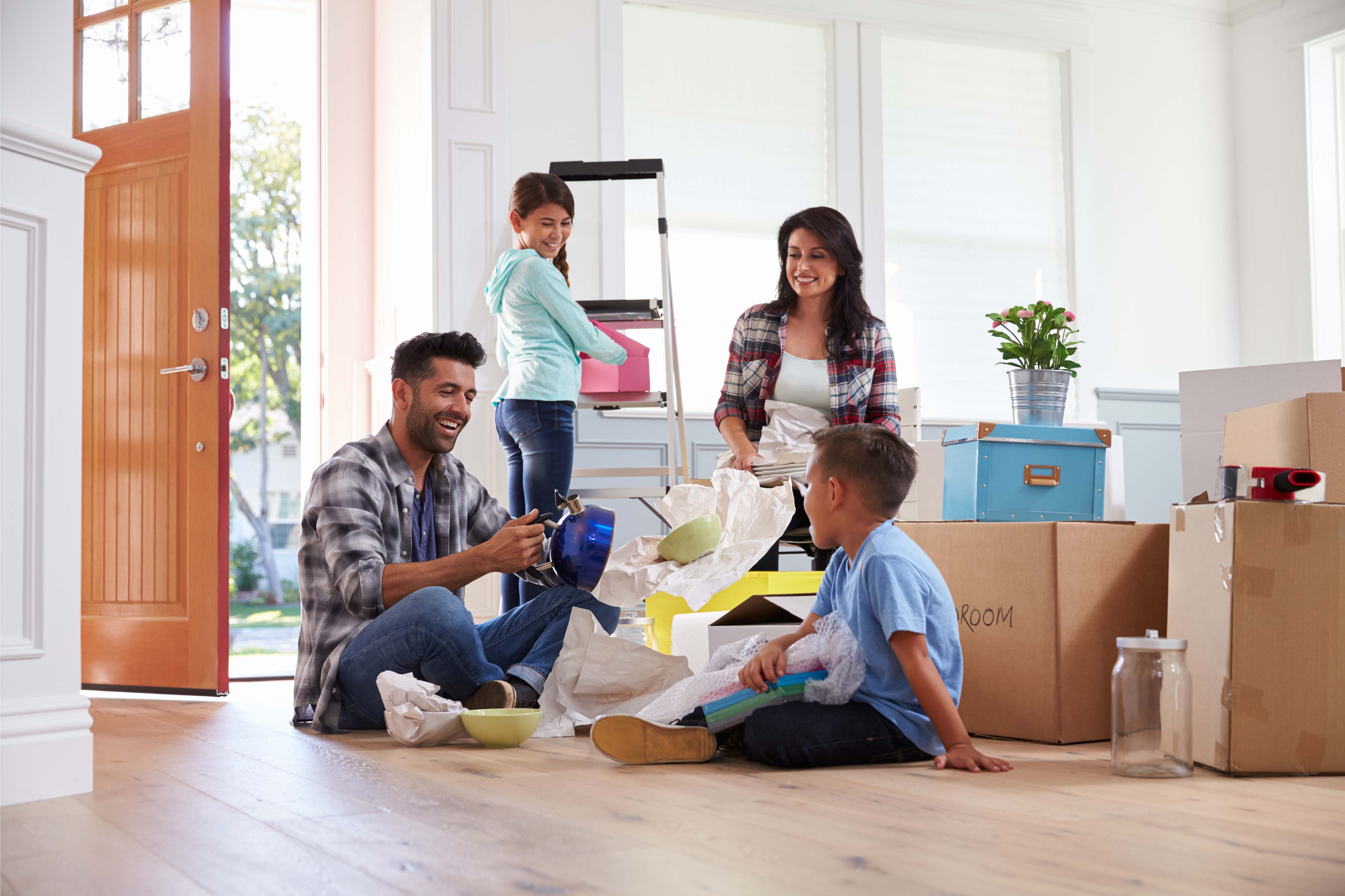 A family busy packing boxes getting ready to move into their new home