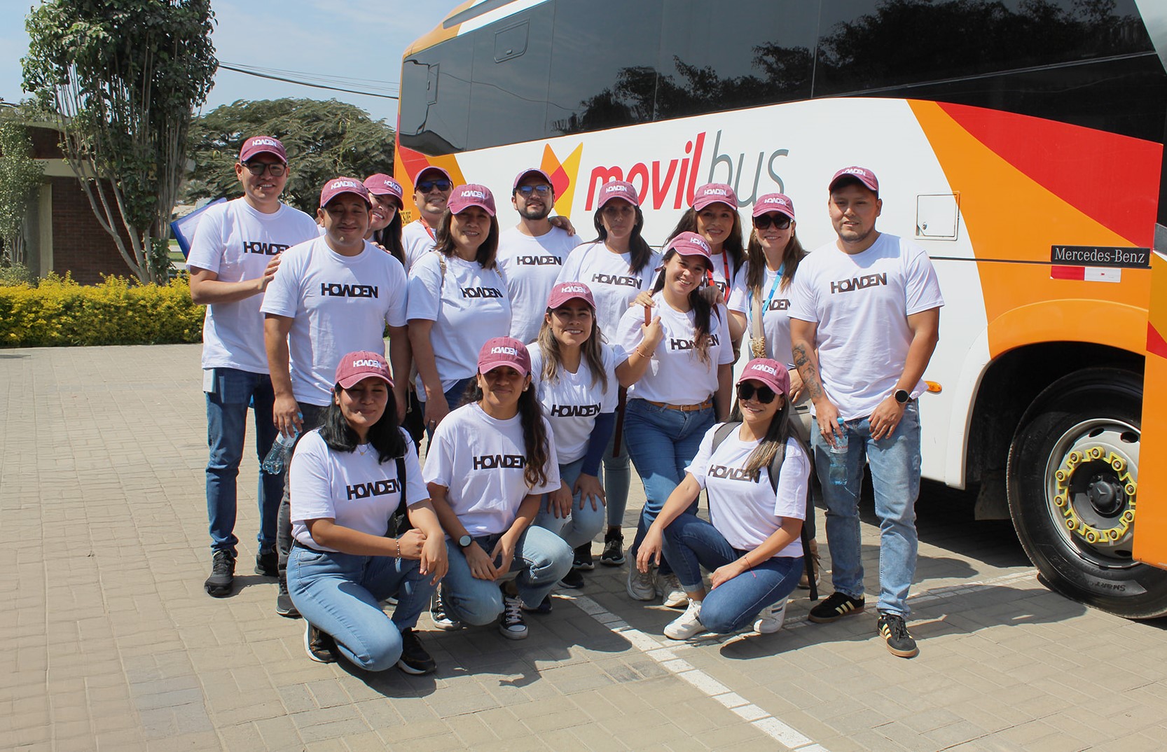 A group of Howden volunteers posing outside a bus