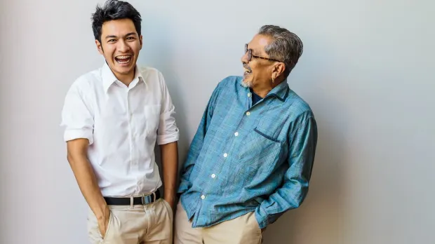 Father and son sharing a joke and laughing - Universal Life Insurance Howden Malaysia