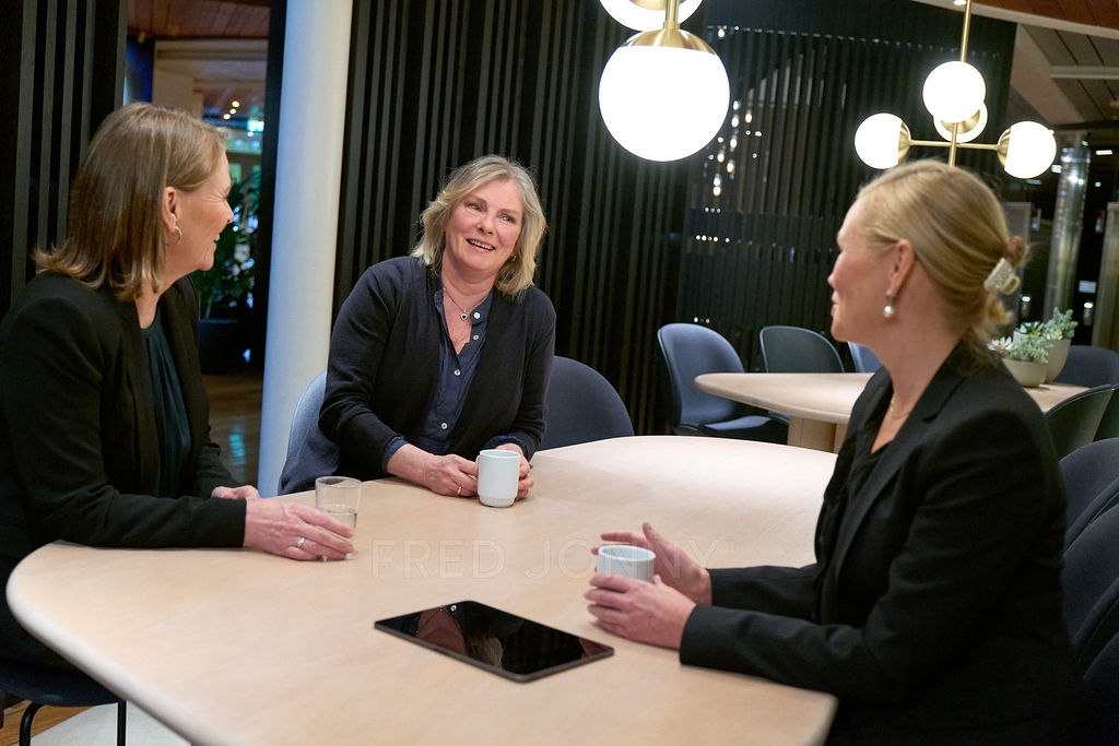3 people talking at a table