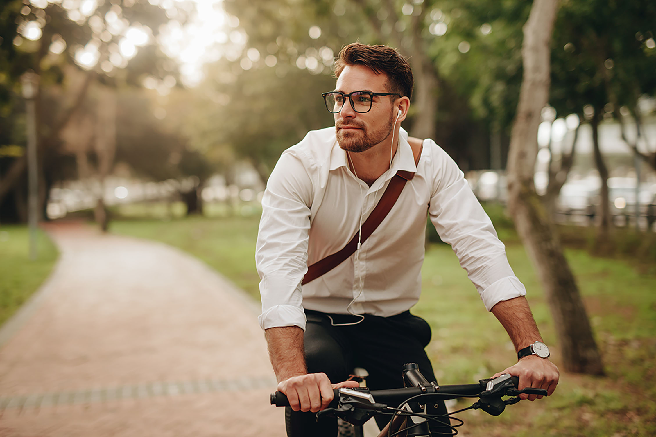 a man cycling to work through a park