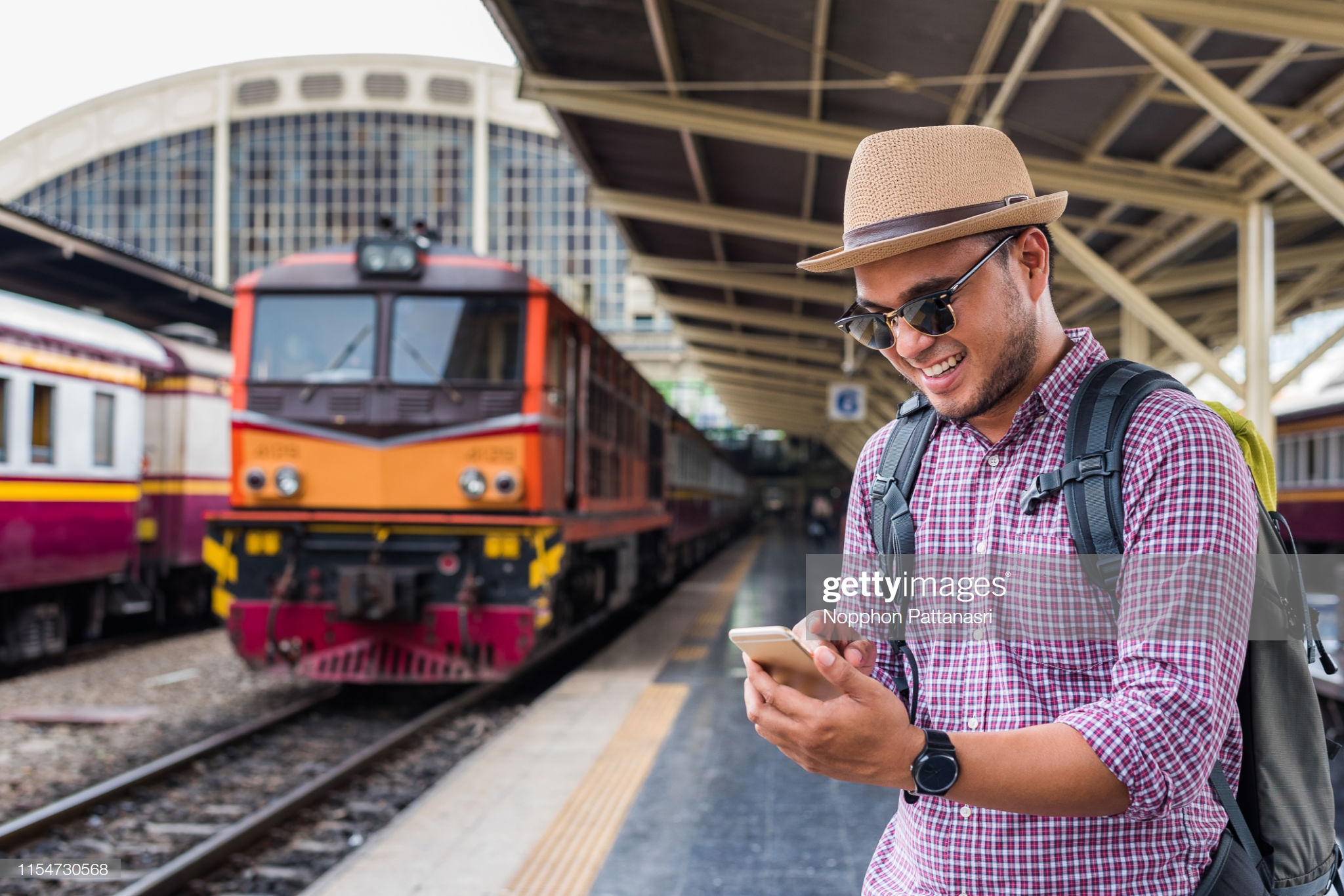 Man at a train station with train in background