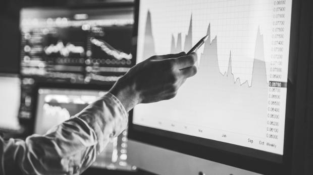 Analyst in action studying graphs on screen