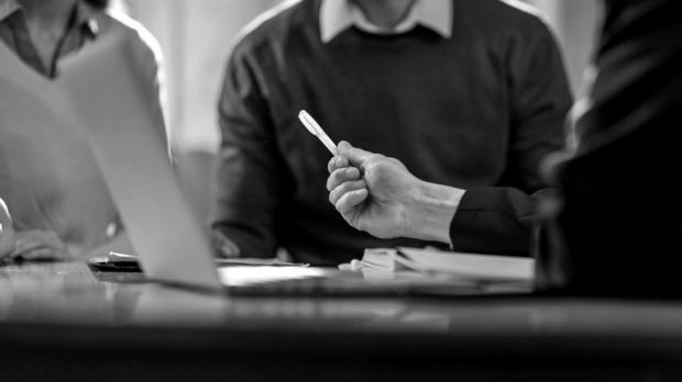 Pen being offer to couple to sign the contract