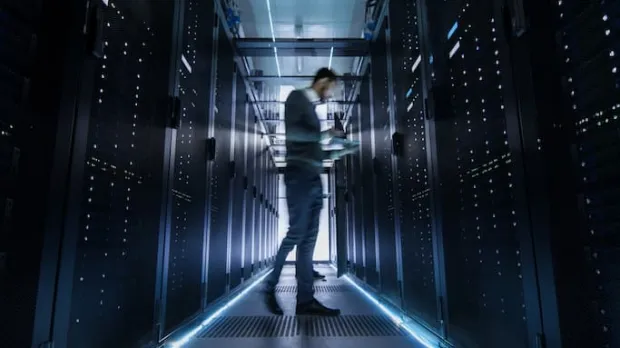 IT engineer examining server racks IT engineer examining server racks