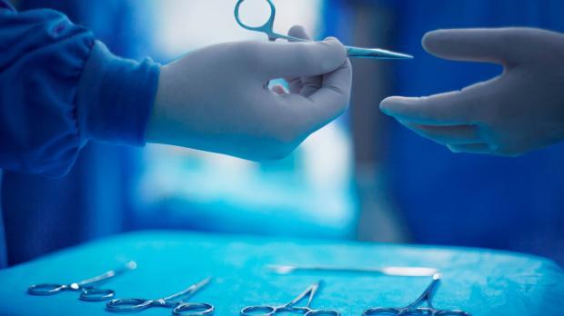 doctor passing scissors