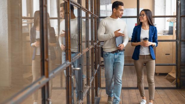 2 colleagues discussing work while walking