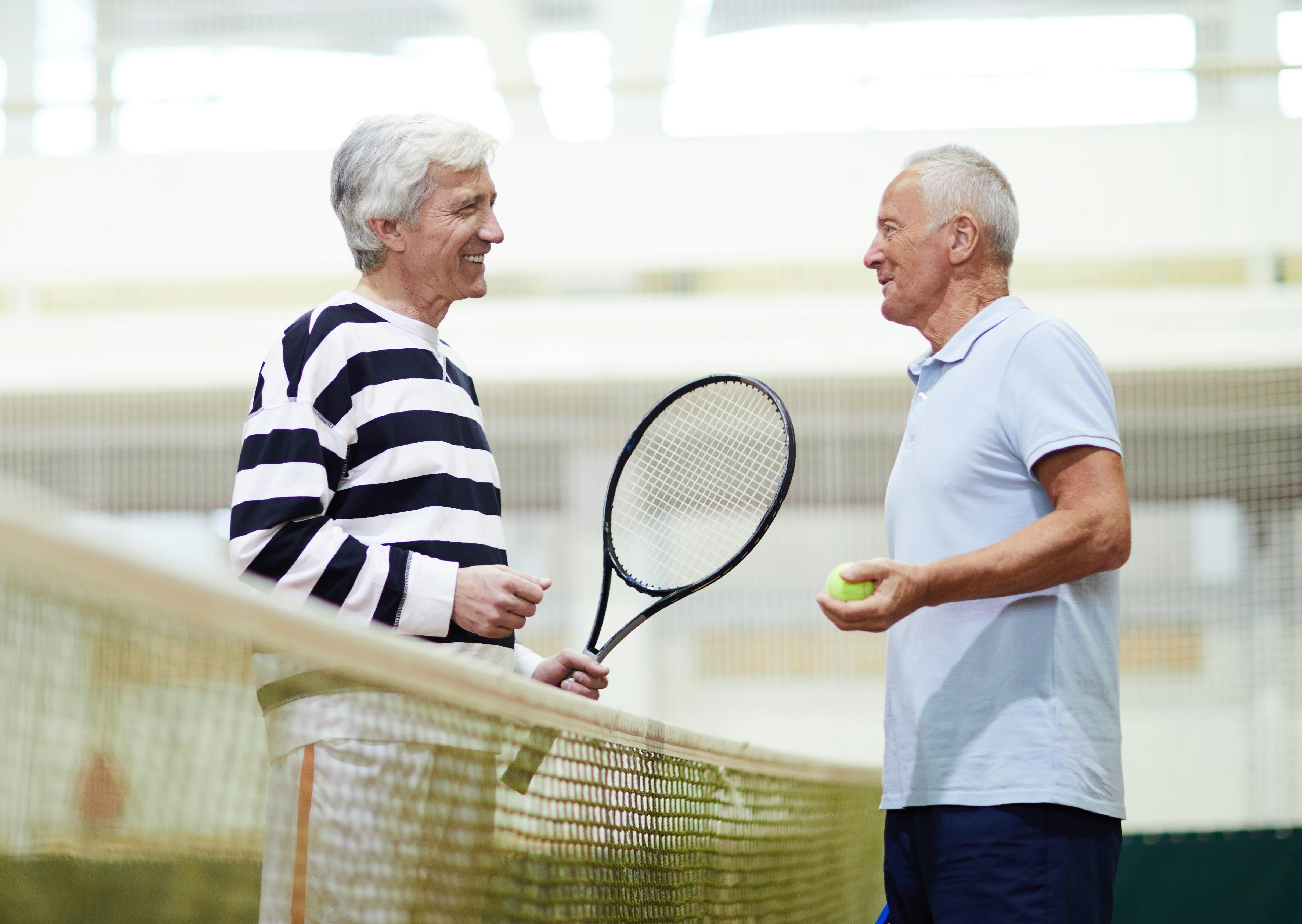 Senior men playing tennis