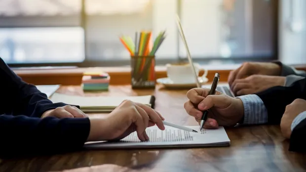 Two businessmen signing a contract Two businessmen signing a contract