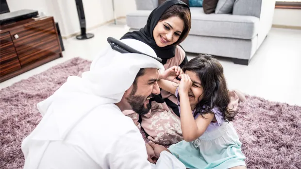arabic family bonding at home A happy Emirati family spending time together at home, symbolising the importance of financial protection and group life insurance in the UAE.