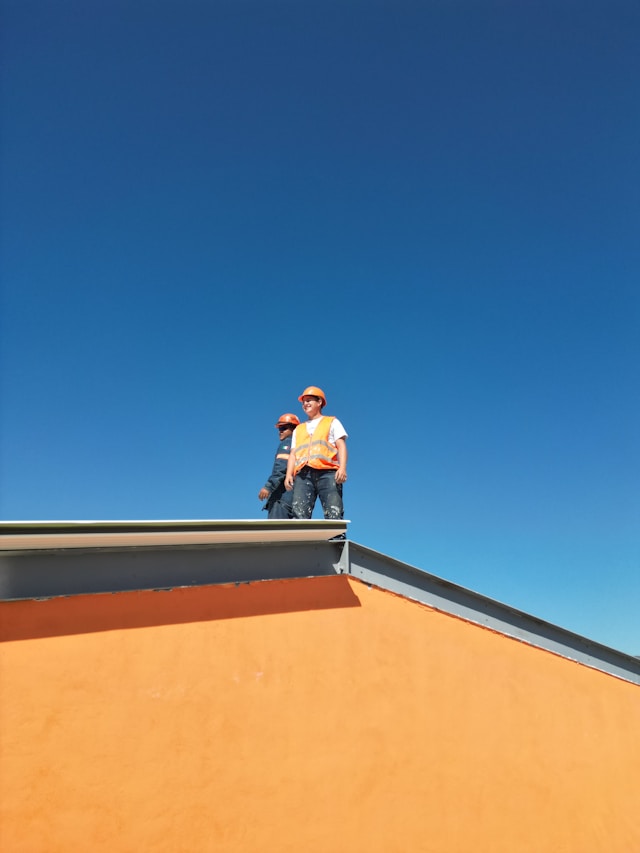 Two builders on a house roof