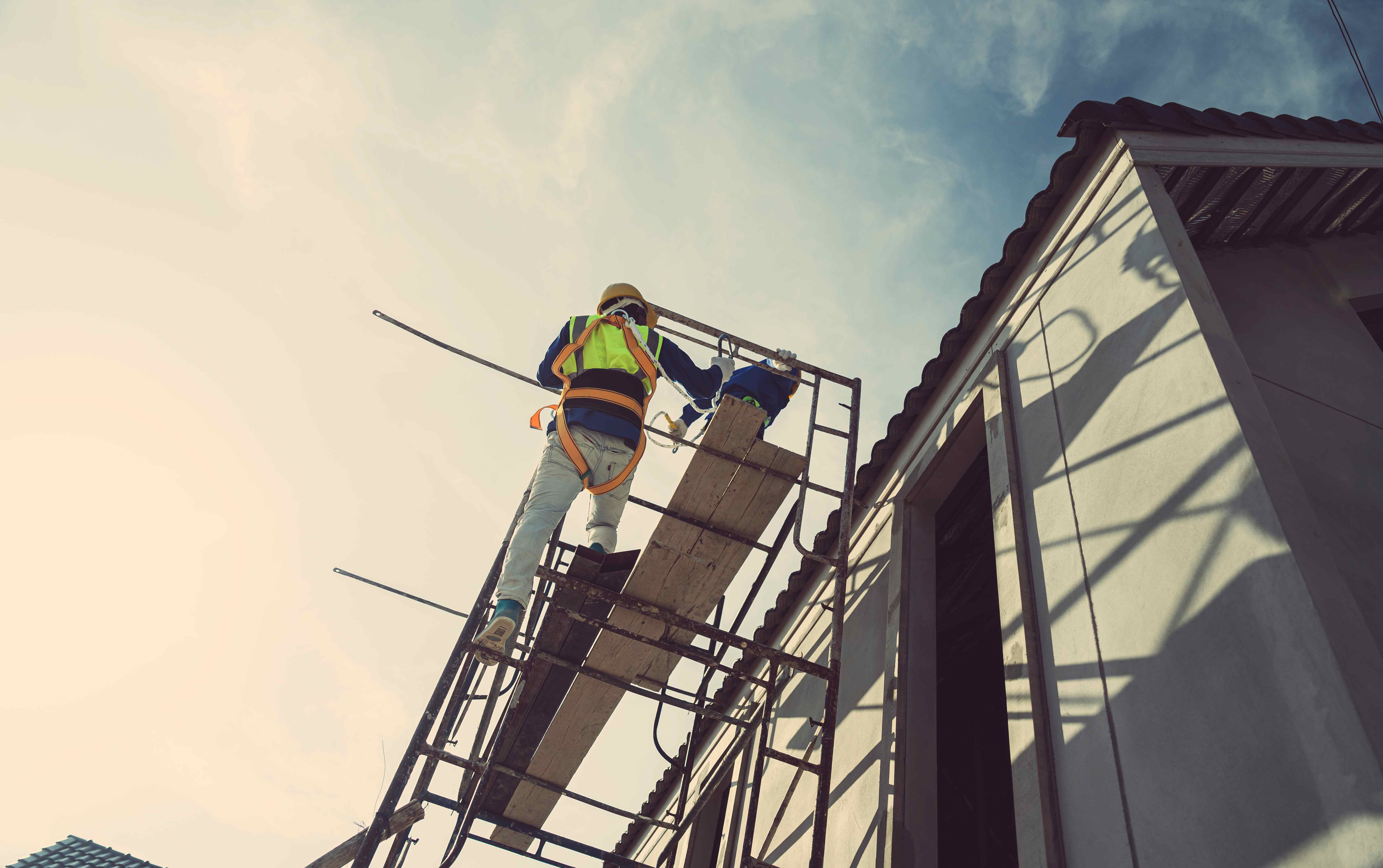 Contractors on scaffolding working on a corrugated roof
