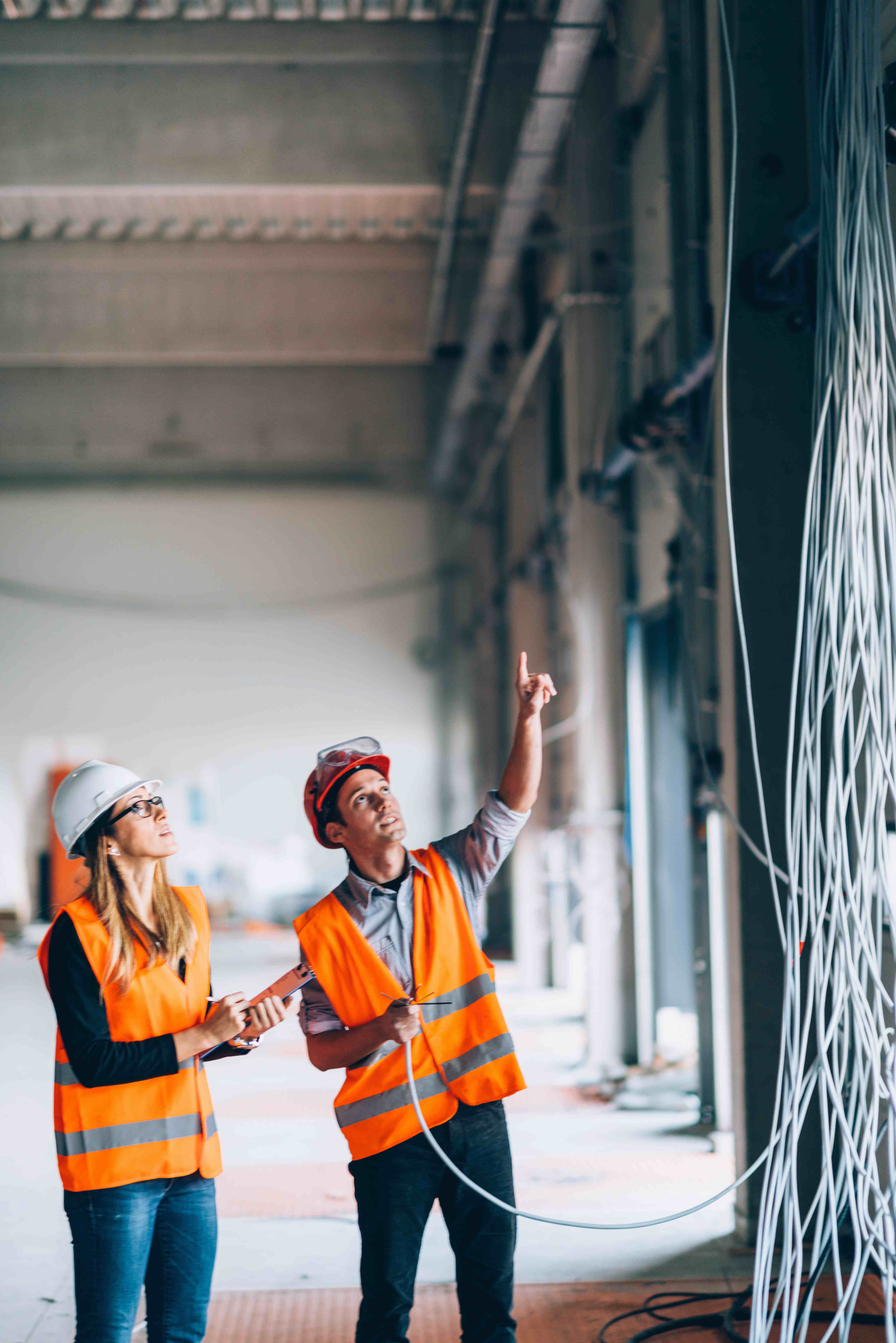 Two contractors looking at cables and wiring