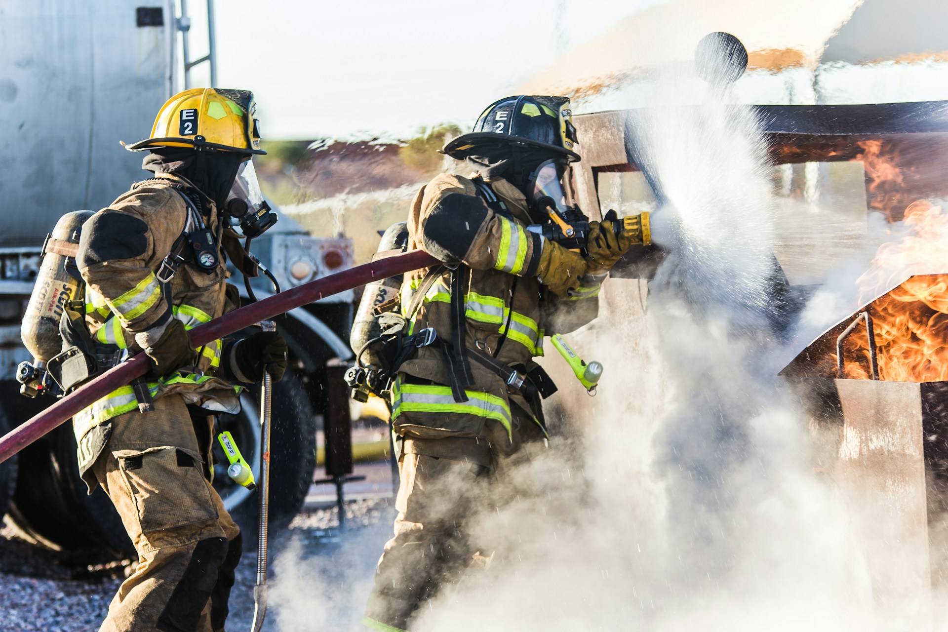 Firefighters using a hose on a fire outdoors
