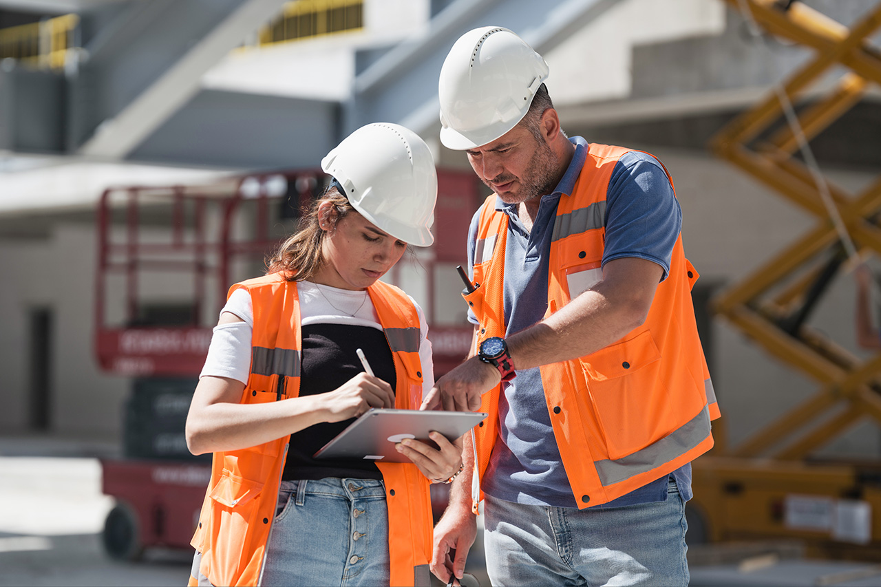 Two construction workers looking at a clipboard