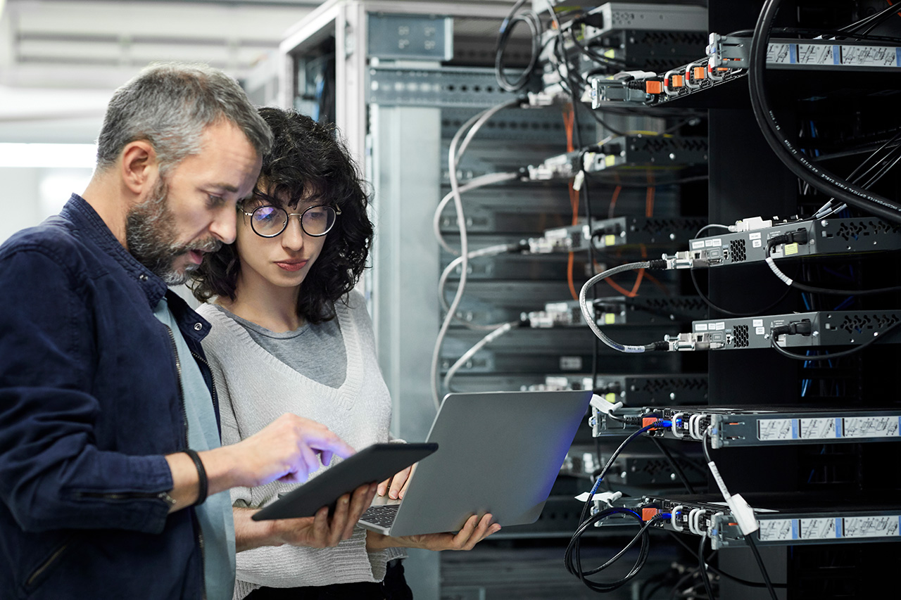 Two people working in a server room